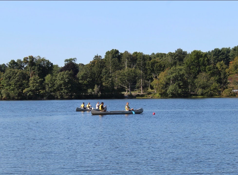 Campers canoe on the water. 