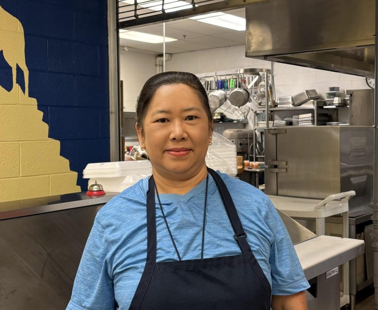 Mrs. Ng in front of the OSHS kitchen, preparing for lunch (10/11). 