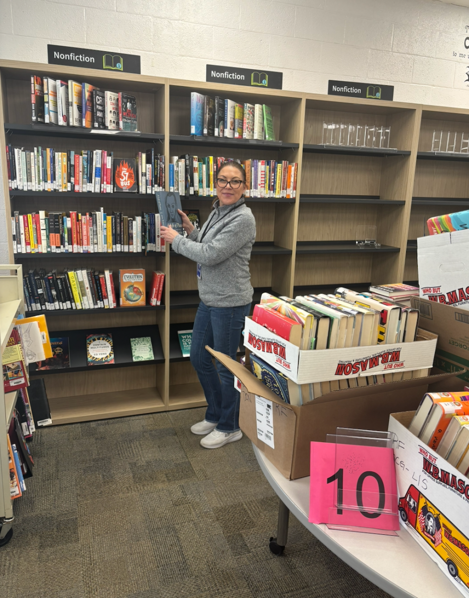 Mrs. Casolino unpacking books onto the new shelves. 
