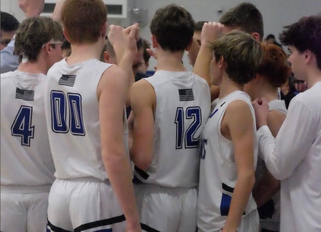 The boys basketball team in their pregame huddle.